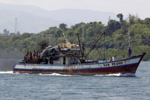 Filipino fishermen wave from a fishing boat bound to fish near Scarborough Shoal in Masinloc