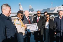 Prime Minister Abiy Ahmed holds a handover certificate in front of an Su-35 fighter jet bearing the Ethiopian flag.