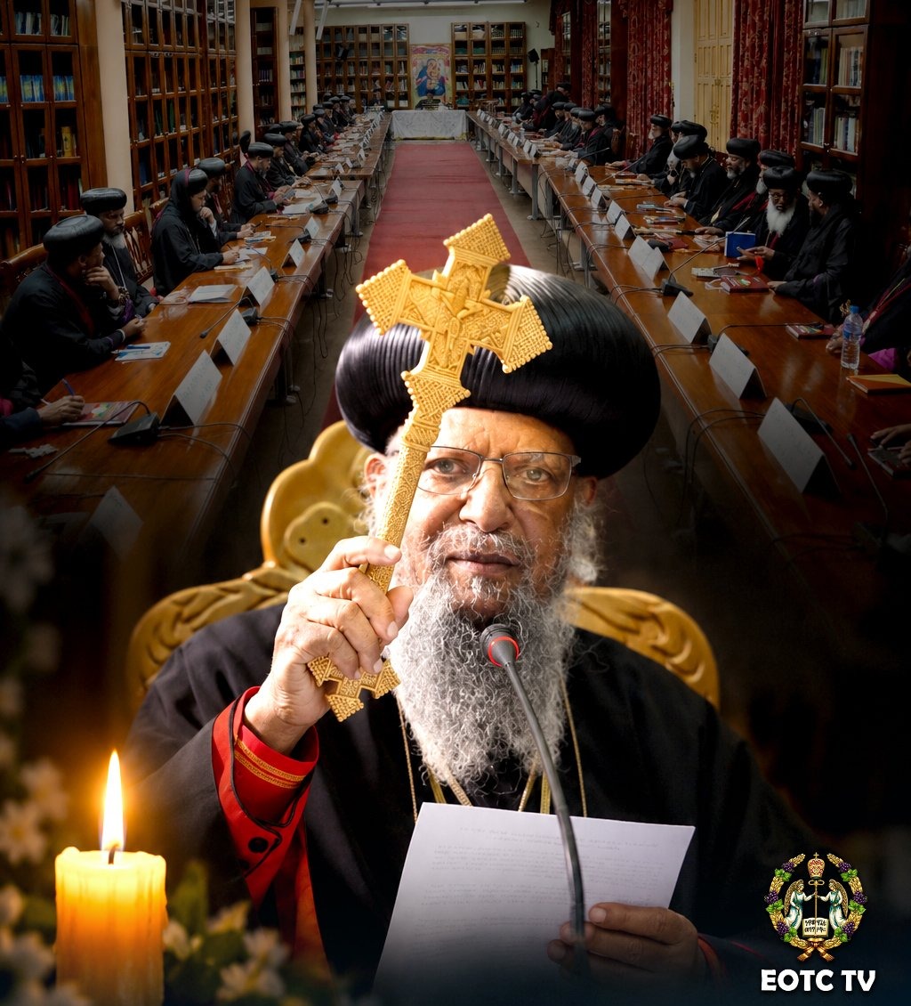 Graphic from EOTC TV: a bearded cleric in a black turban and robes holds up a gold cross as he reads from a paper at a microphone, with a lit candle beside him and bishops seated at long tables in the Holy Synod hall behind him.